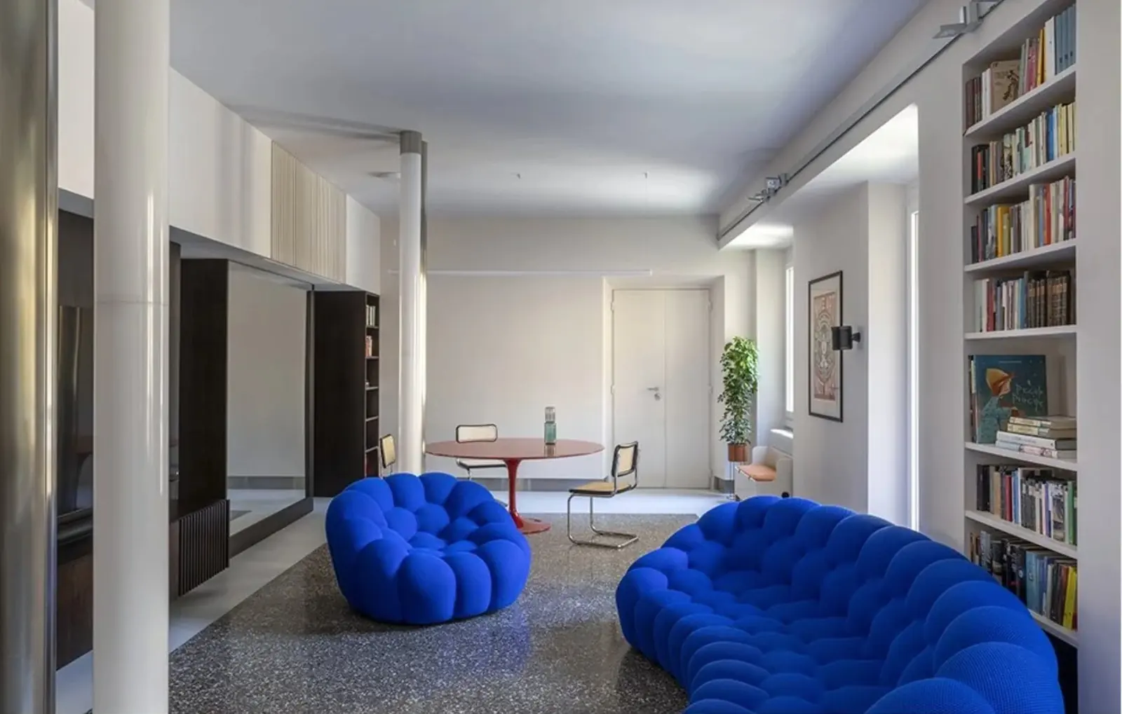 Soggiorno open space di Casa Poma ai Prati, con pavimento in seminato originale e divani blu